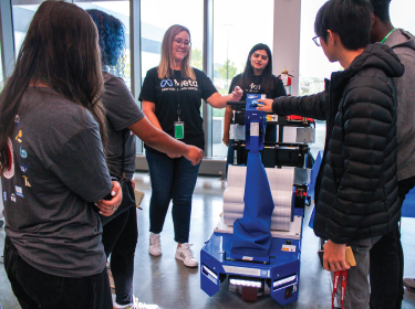 Meta staff with robot and students